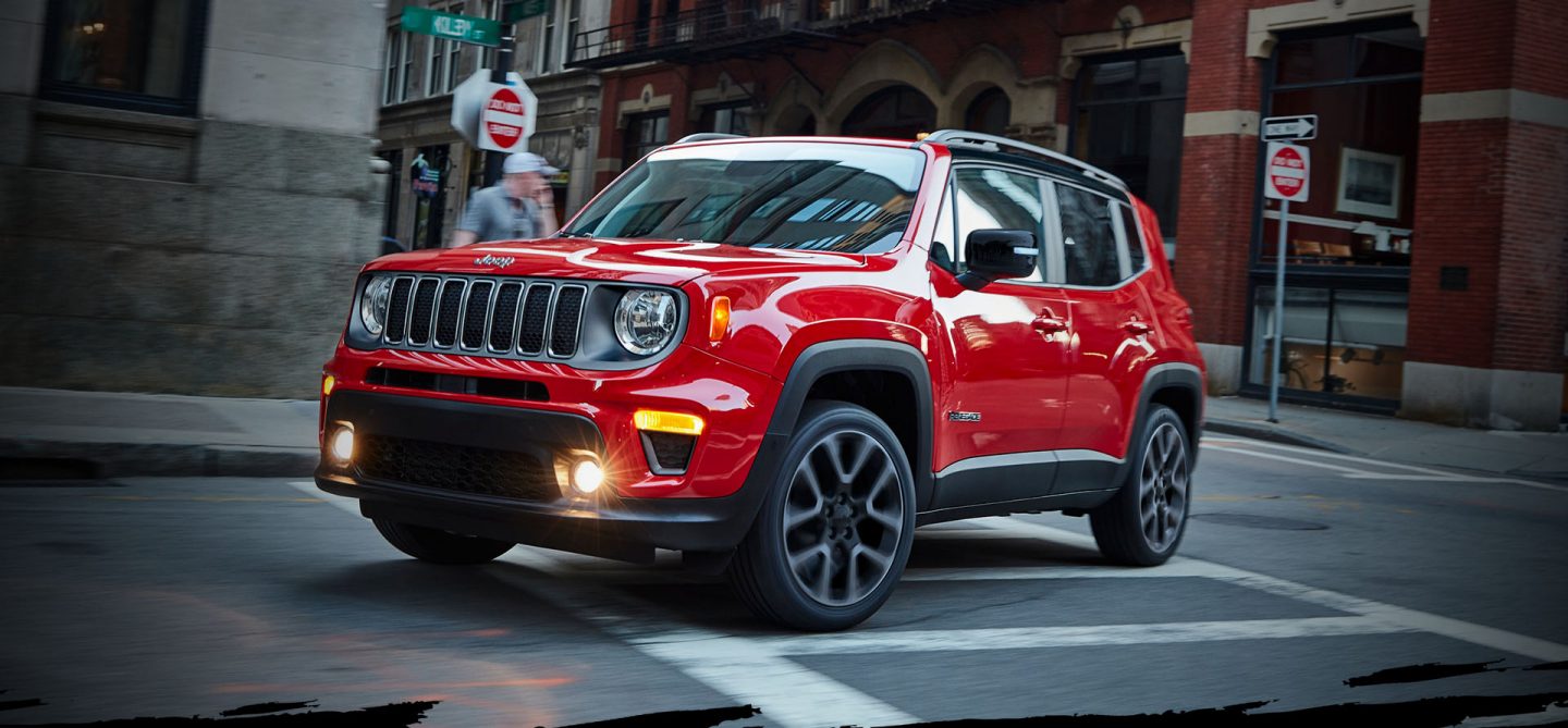 The 2022 Jeep Renegade Limited being driven through an intersection of two streets in a city center.