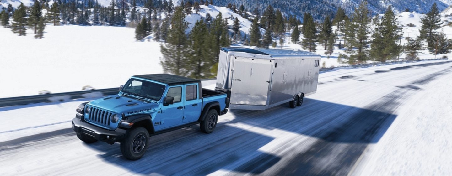 The 2023 Jeep Gladiator Overland with its headlamps and fog lamps lit, being driven through a tunnel.