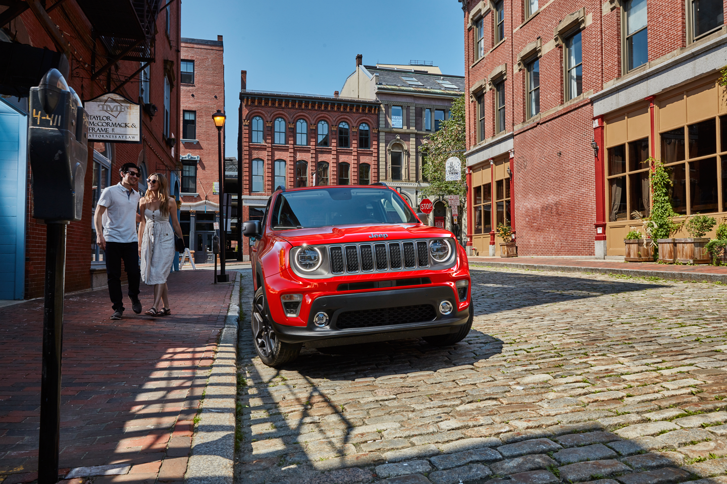 The 2023 Jeep Renegade Limited being driven through an intersection of two streets in a city center.