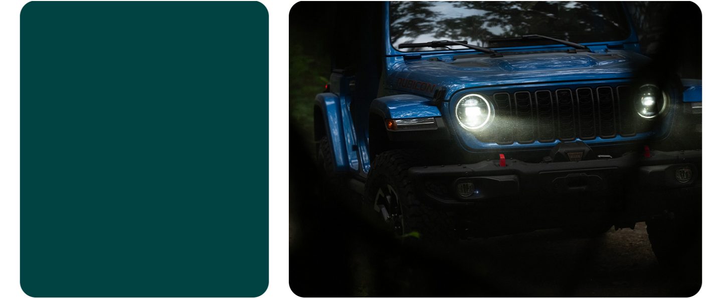The front end of a blue 2026 Jeep Wrangler Rubicon X with its headlamps on.