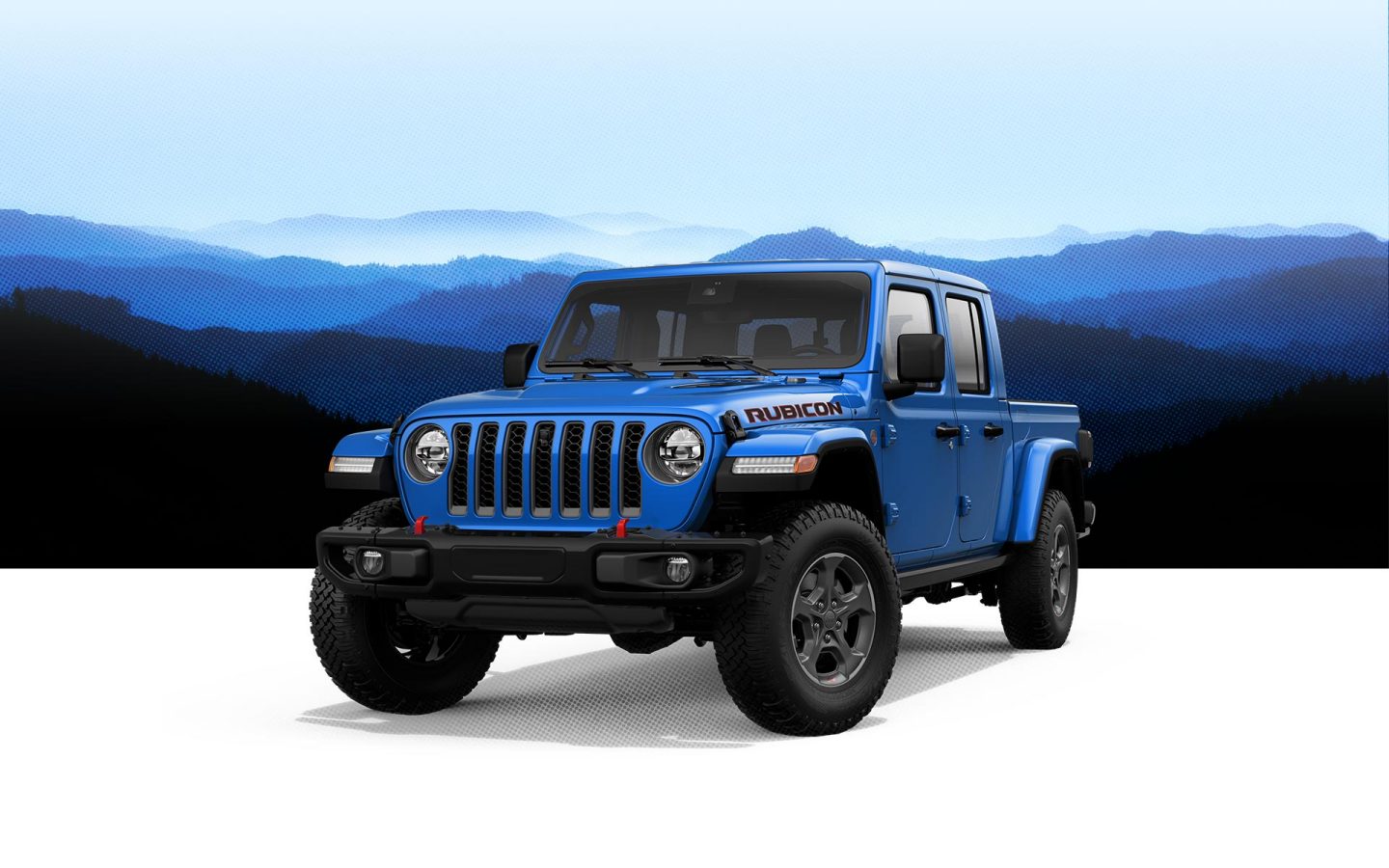 Blue gladiator Rubicon posed in front of a foggy blue mountain landscape