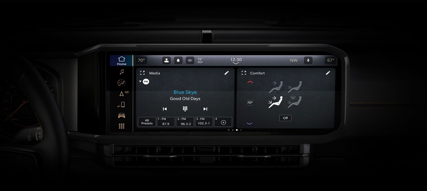 A close-up of the Uconnect 5 Nav touchscreen in the 2024 Jeep Wrangler with a split-screen displaying the radio selection and climate controls.